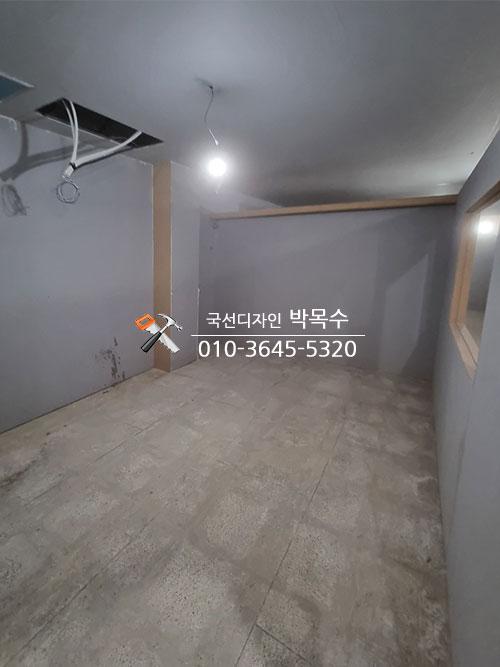 회색 벽면과 천장 전구, 전선이 설치된 빈 공간