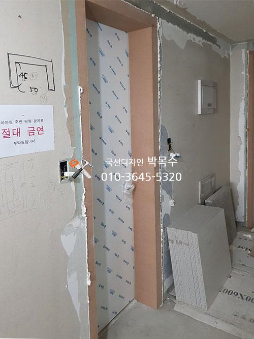 벽지와 도어 프레임이 설치된 벽면의 마감 상태