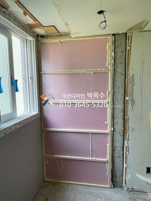 벽면에 분할 부착된 핑크색 보드와 천장 철거 상태