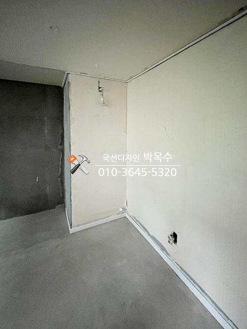 전기 소켓이 설치된 흰색 벽면과 콘크리트 바닥