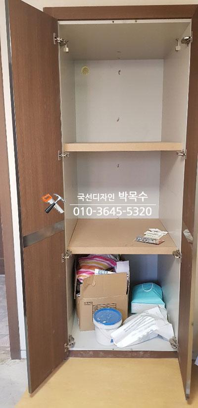 우드톤 가구와 회색 유리 슬라이딩도어가 설치된 드레스룸