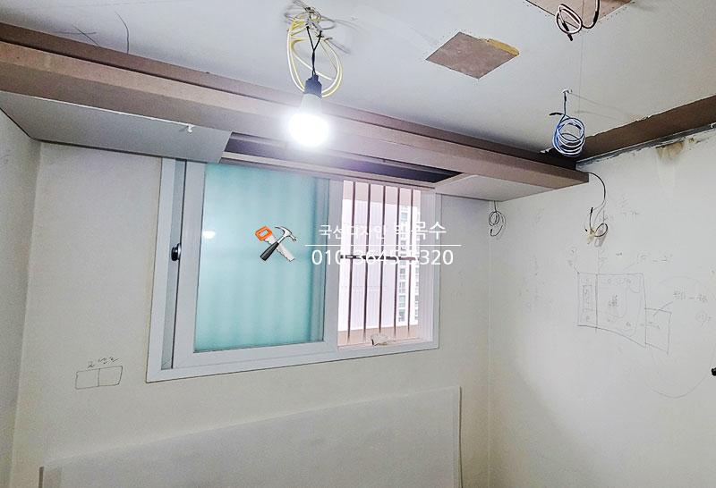 전선이 노출된 벽면과 창호가 보이는 실내