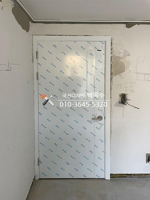 보호 필름이 붙은 문과 전선 구멍이 보이는 벽면
