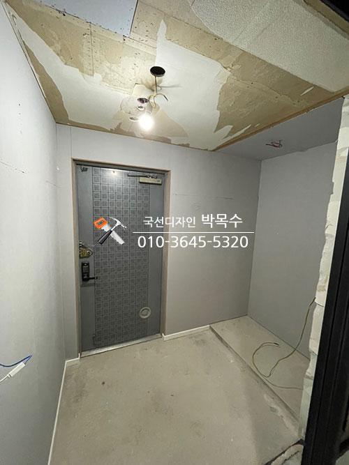 천장이 부분적으로 벗겨진 상태의 현관 공간