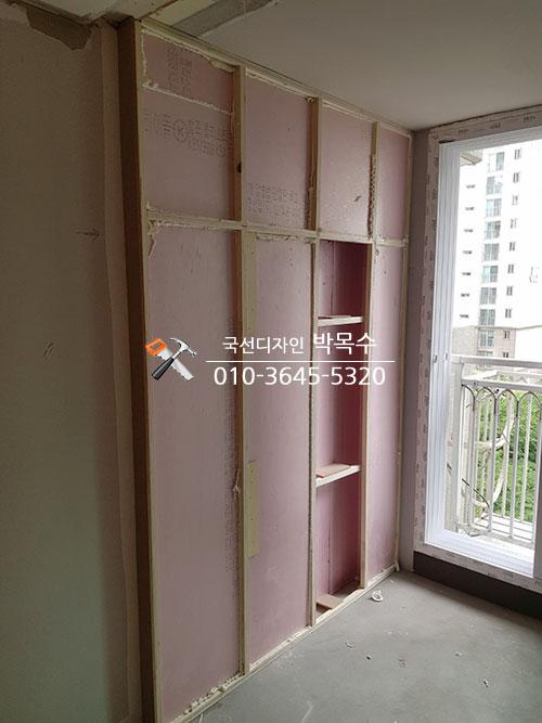 핑크색 보드 구조물이 설치 중인 발코니 벽면