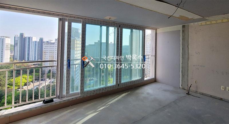 외부 풍경이 보이는 슬라이딩 창호와 콘크리트 바닥
