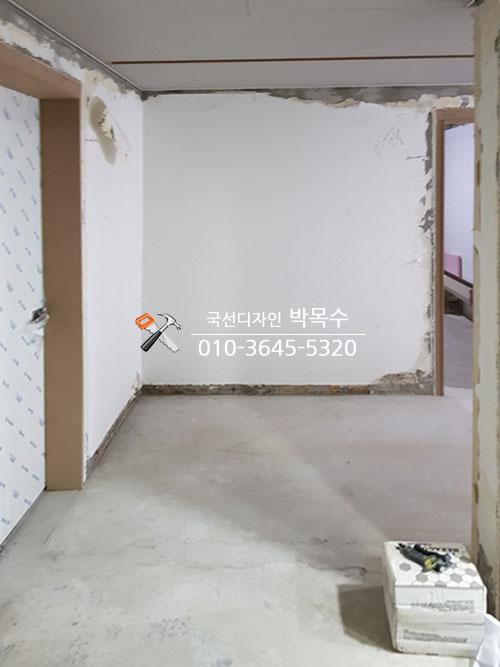 흰색 마감재가 일부 벗겨진 콘크리트 바닥의 공간