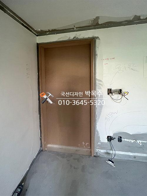 흰색 페인트와 전선이 노출된 문 주변 마감 작업