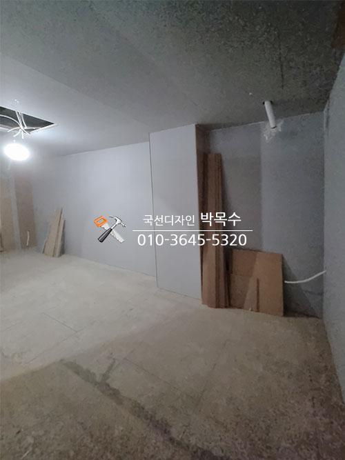 바닥 타일 위에 목재판과 보드를 배치한 시공 전 공간