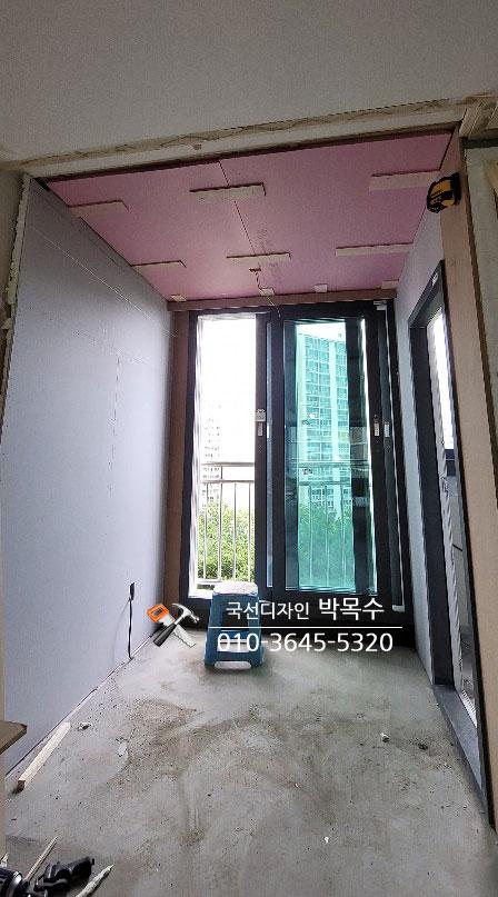 핑크색 보드로 천장을 마감하고 전선을 정리 중인 복도