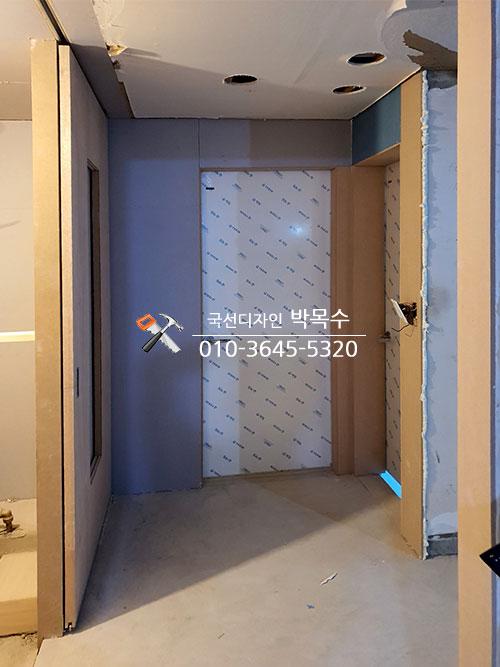 천장 구멍과 문 구조물이 보이는 복도