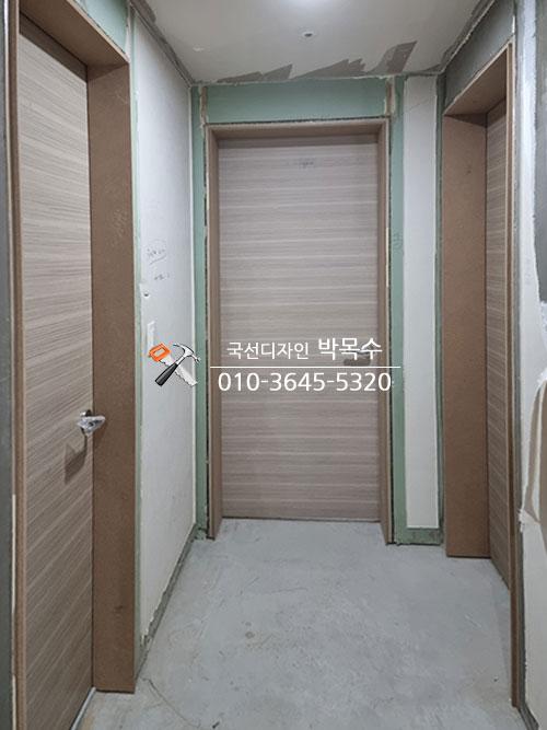베이지색 도어와 갈색 문틀이 보이는 복도