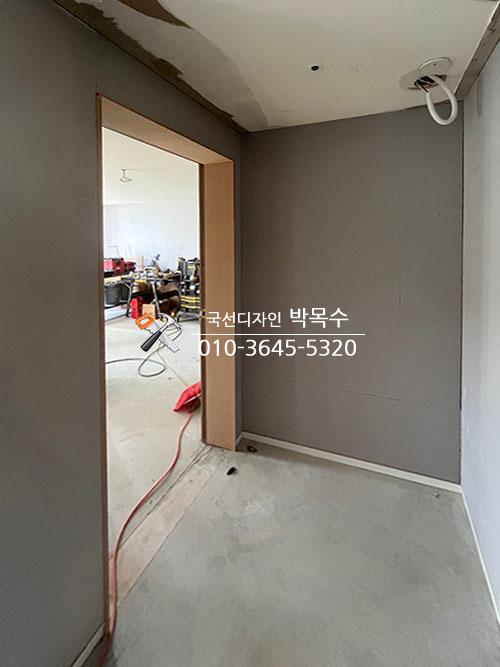 갈색 문틀이 설치된 회색 톤의 복도 공간