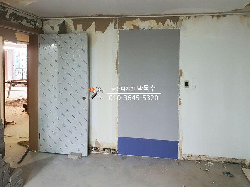 도어 설치 후 벽면 일부를 정리하는 모습