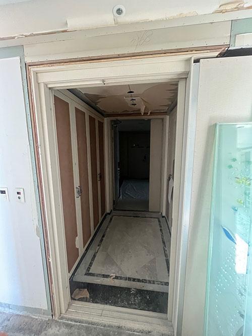 벽지가 제거되어 내부 보드가 드러난 복도