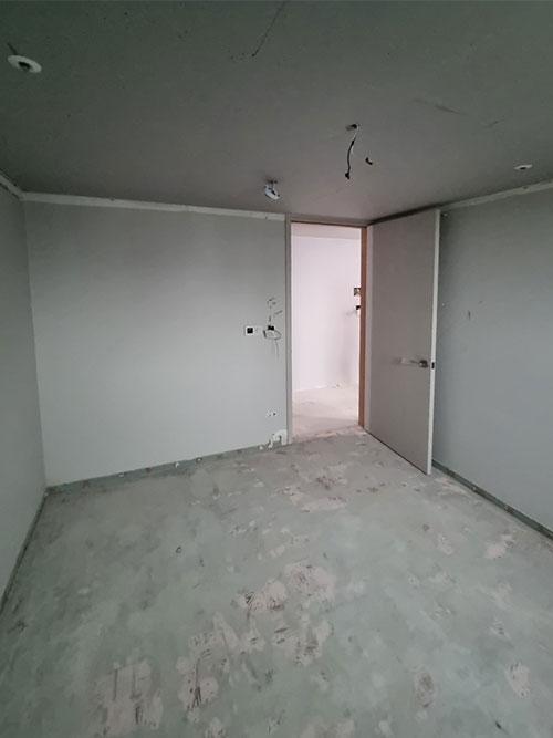 배선이 노출된 콘크리트 바닥과 흰 벽면