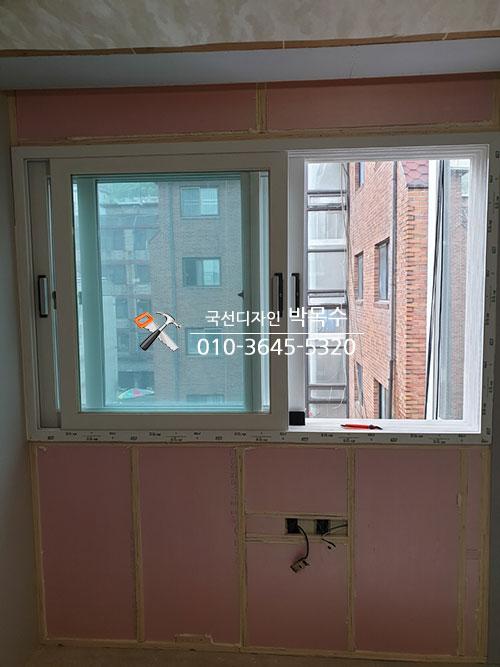 핑크색 보드가 보이는 창틀 내부 프레임