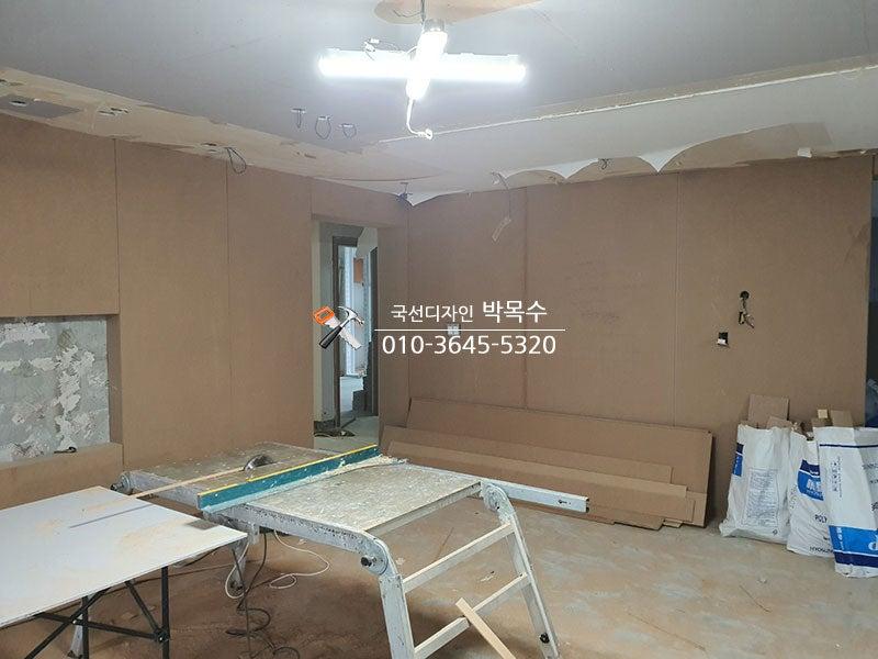 벽면 마감을 위해 수공구를 사용하는 장면