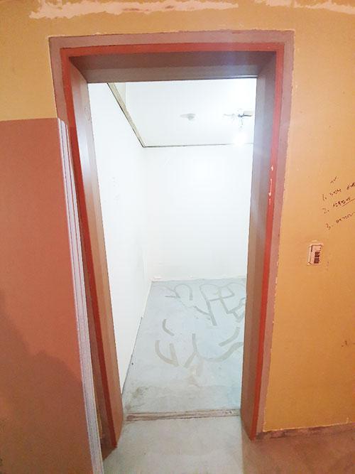 시공 가이드가 적힌 복도 벽면과 갈색 문틀