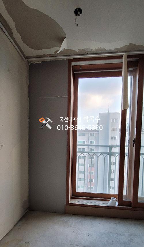 회색 마감 벽면과 천장이 벗겨진 실내