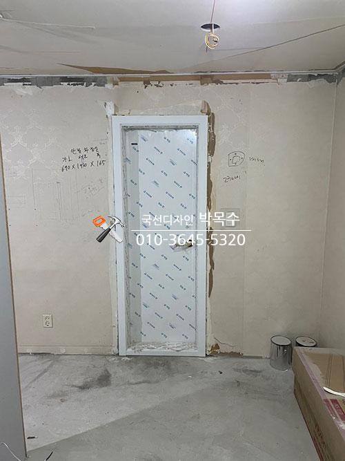 파란색 보호 필름이 붙은 흰색 문틀 설치 모습