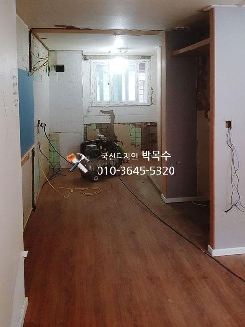 우드톤 바닥과 수납장, 창문이 배치된 공간