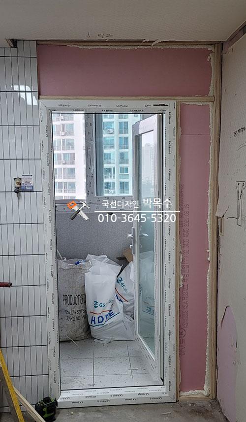 유리문 설치 중인 흰색 타일 벽면 공간