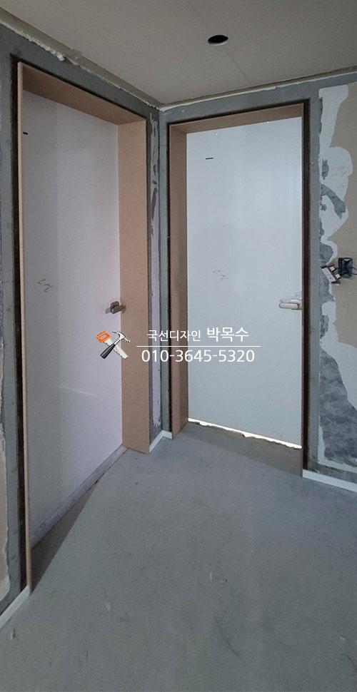 문틀과 문짝이 설치된 회색 콘크리트 바닥의 복도