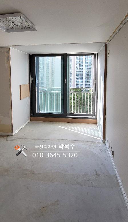슬라이딩 유리문 너머로 외부 풍경이 보이는 마감 전 공간