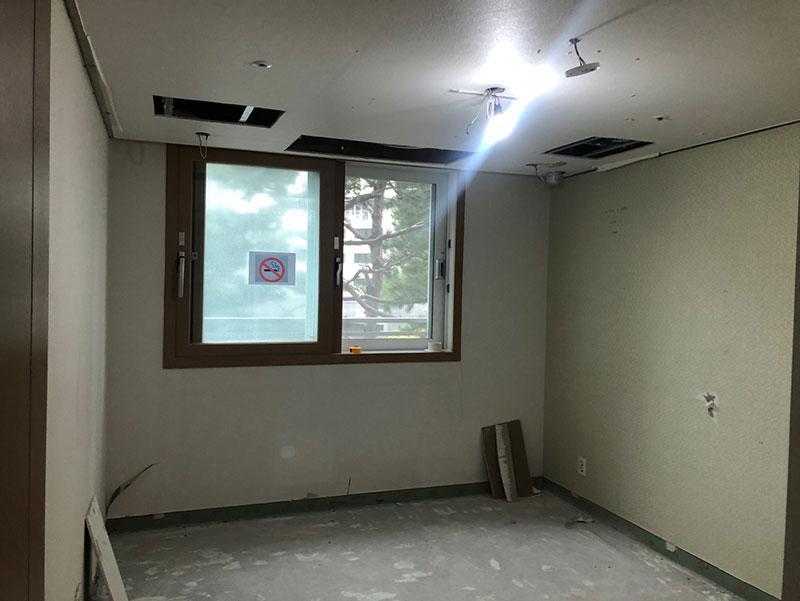 베이지색 벽면과 배관 구멍이 보이는 공간