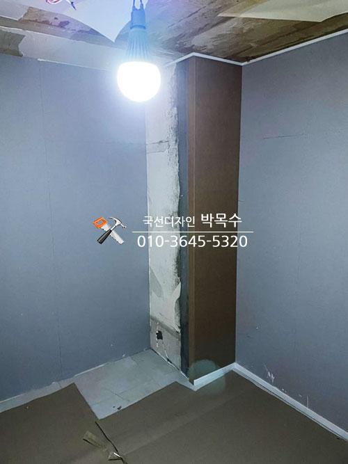 회색 벽면과 갈색 타일 바닥의 천정 석고 작업
