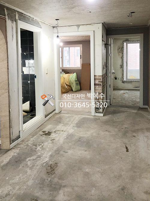 전등이 매달린 복도의 콘크리트 바닥과 벽면