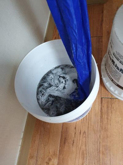 흰 플라스틱 통에 담긴 검은 액체와 거품