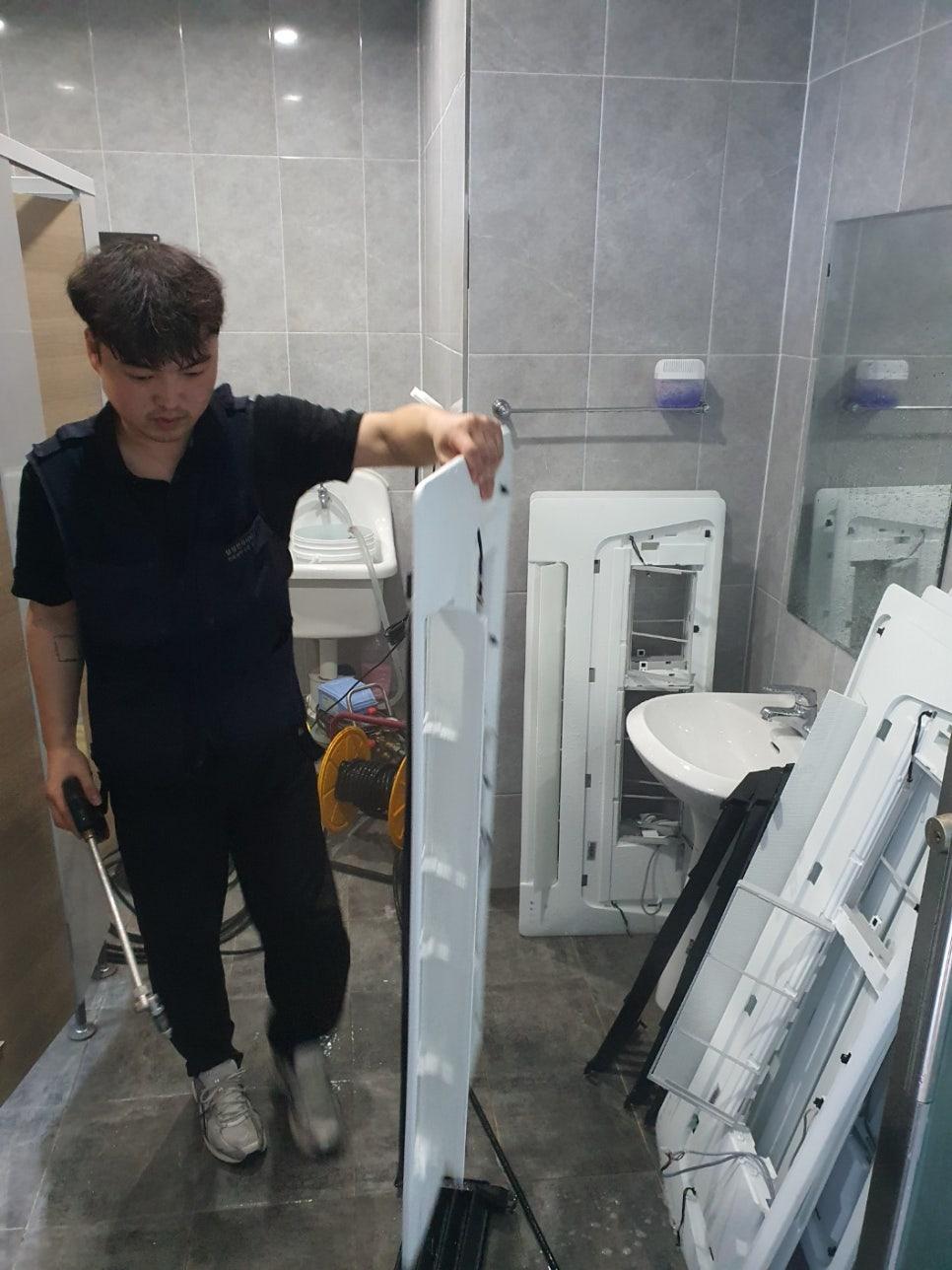 회색 타일이 깔린 욕실 내에서 진행되는 세척 작업