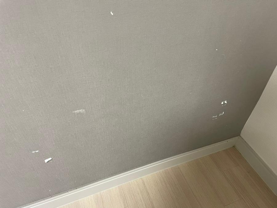 회색 벽지와 목재 바닥이 보이는 실내 공간