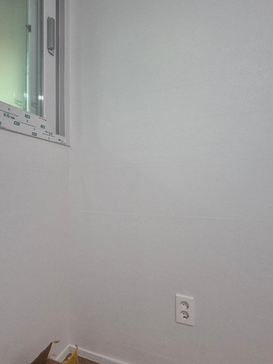 전기 소켓과 창호 주변의 정돈된 흰 벽면