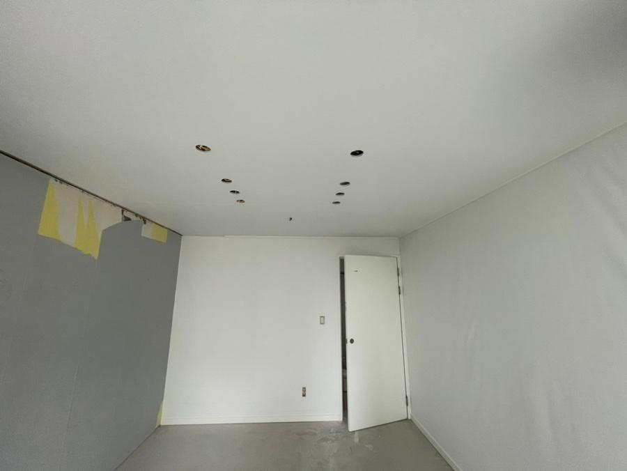 회색 바닥과 화이트 벽지로 마감된 방