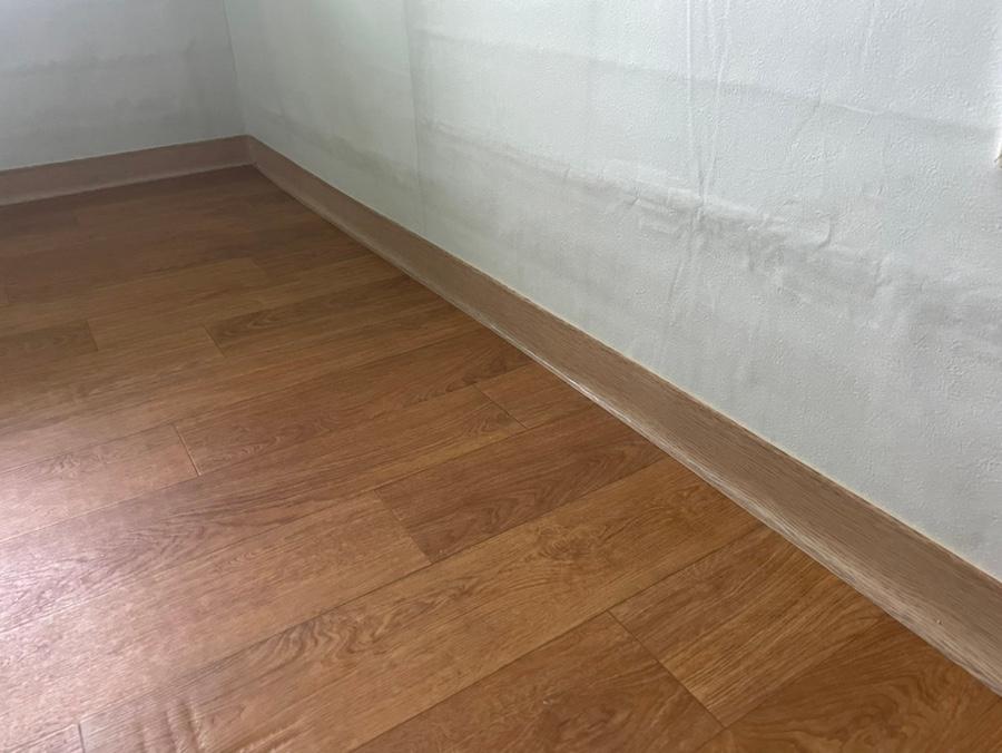 목재 바닥과 깨끗한 흰 벽이 마주한 공간
