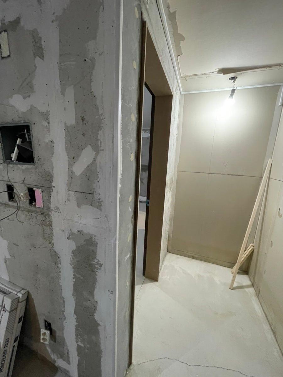전선이 노출된 콘크리트 벽과 조명이 설치된 복도