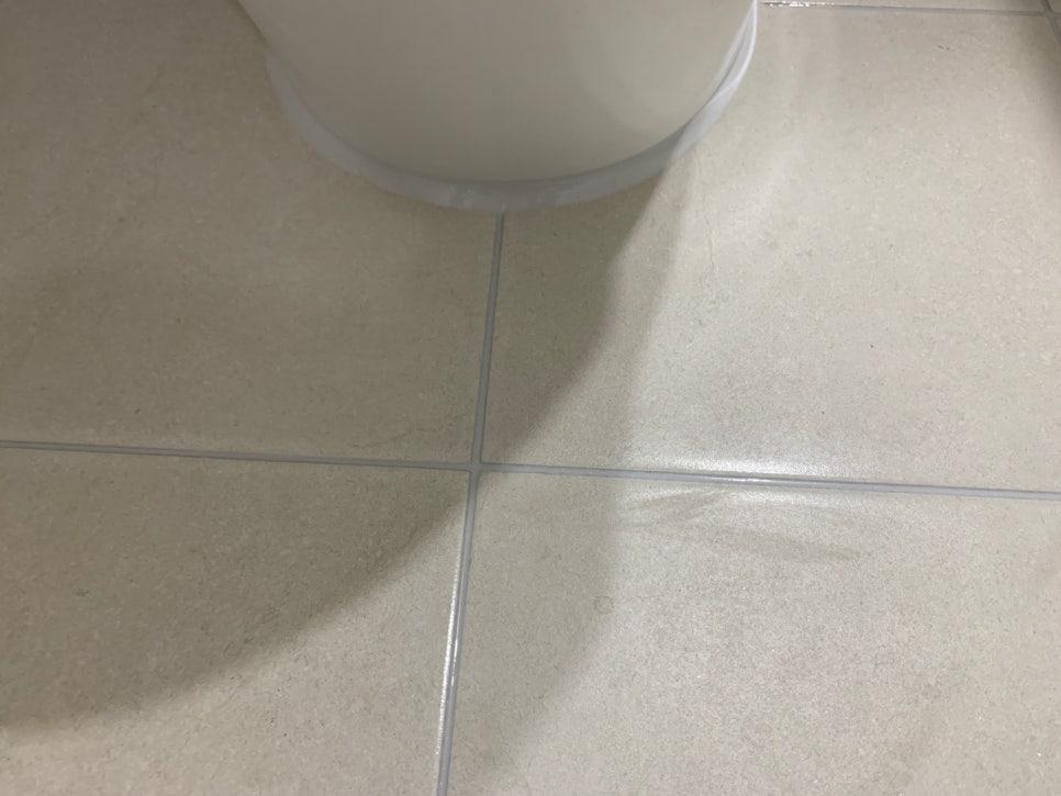 흰색 세라믹 타일 바닥과 욕조 일부가 보이는 공간