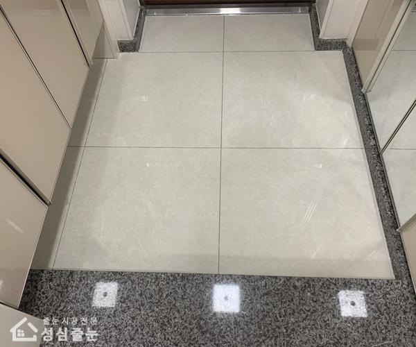 베이지색 수납장이 있는 현관의 화이트 타일 바닥