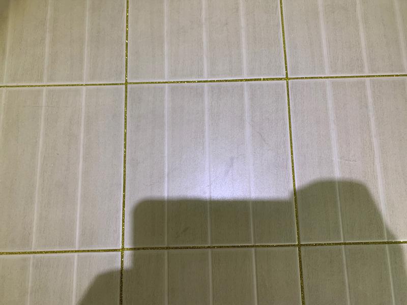흰색 타일 바닥에 금색 틈새가 채워진 모습