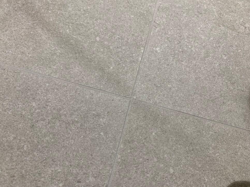회색 타일 바닥의 기존 메지를 제거하는 작업