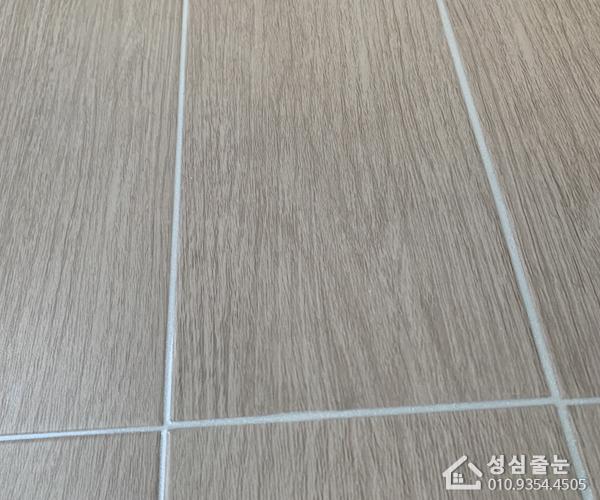 우드톤 타일과 대비되는 흰색 셔틀 틈