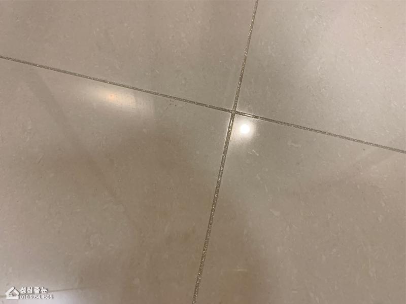 회색 타일 틈새의 줄눈 주입 과정