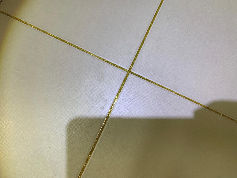 타일 틈새에 주입된 금색 세라믹 자재 근접샷