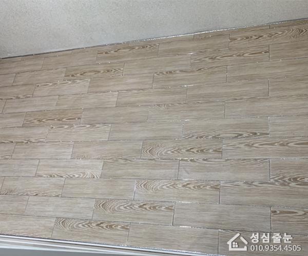 차분한 회색 톤의 목재 패턴 타일 바닥