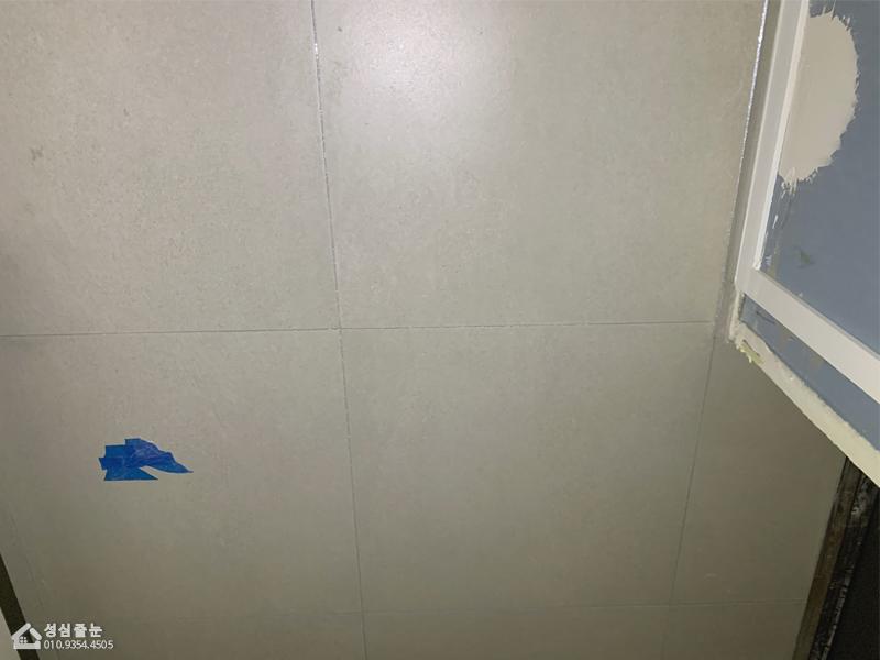 회색 타일 바닥과 흰색 문 프레임이 보이는 공간