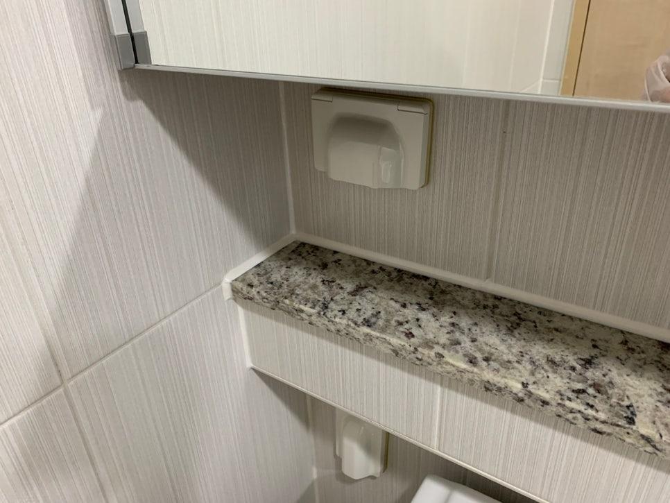 회색 줄무늬 타일 벽면과 흰색 수전 디테일