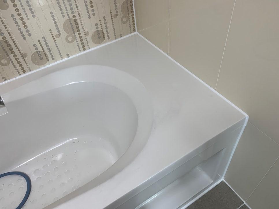 흰색 욕조와 베이지색 타일 벽이 있는 욕실 내부